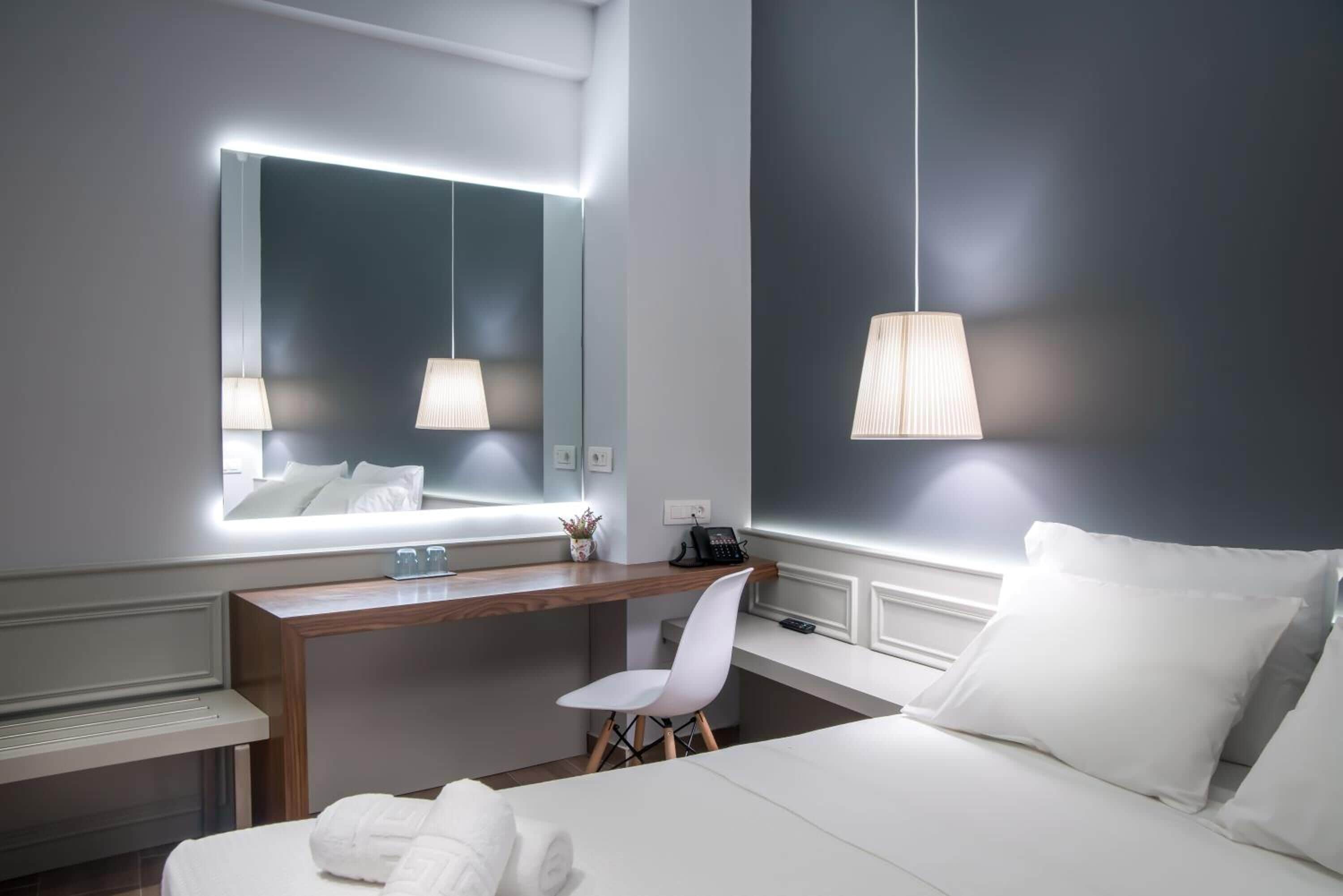 Une chambre d’hôtel moderne équipée d’un grand lit, d’un bureau, d’une chaise et d’une table de chevet.