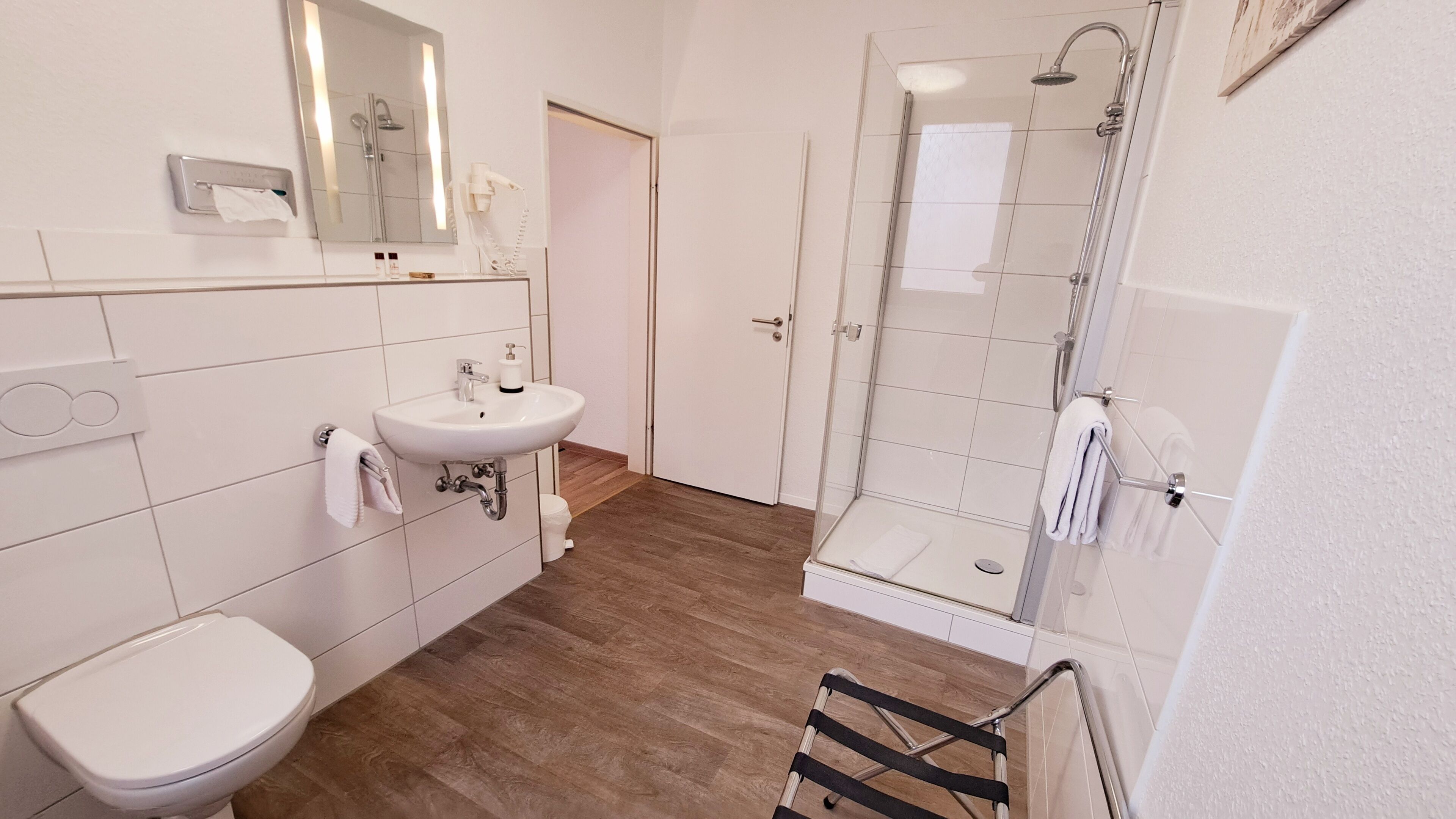 A modern bathroom with a toilet, sink, and shower.