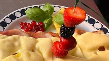 Un piatto con un panino, formaggio e frutta.