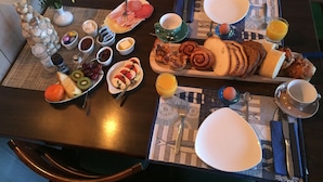 Una mesa de desayuno con diversos alimentos, utensilios y un candelabro.