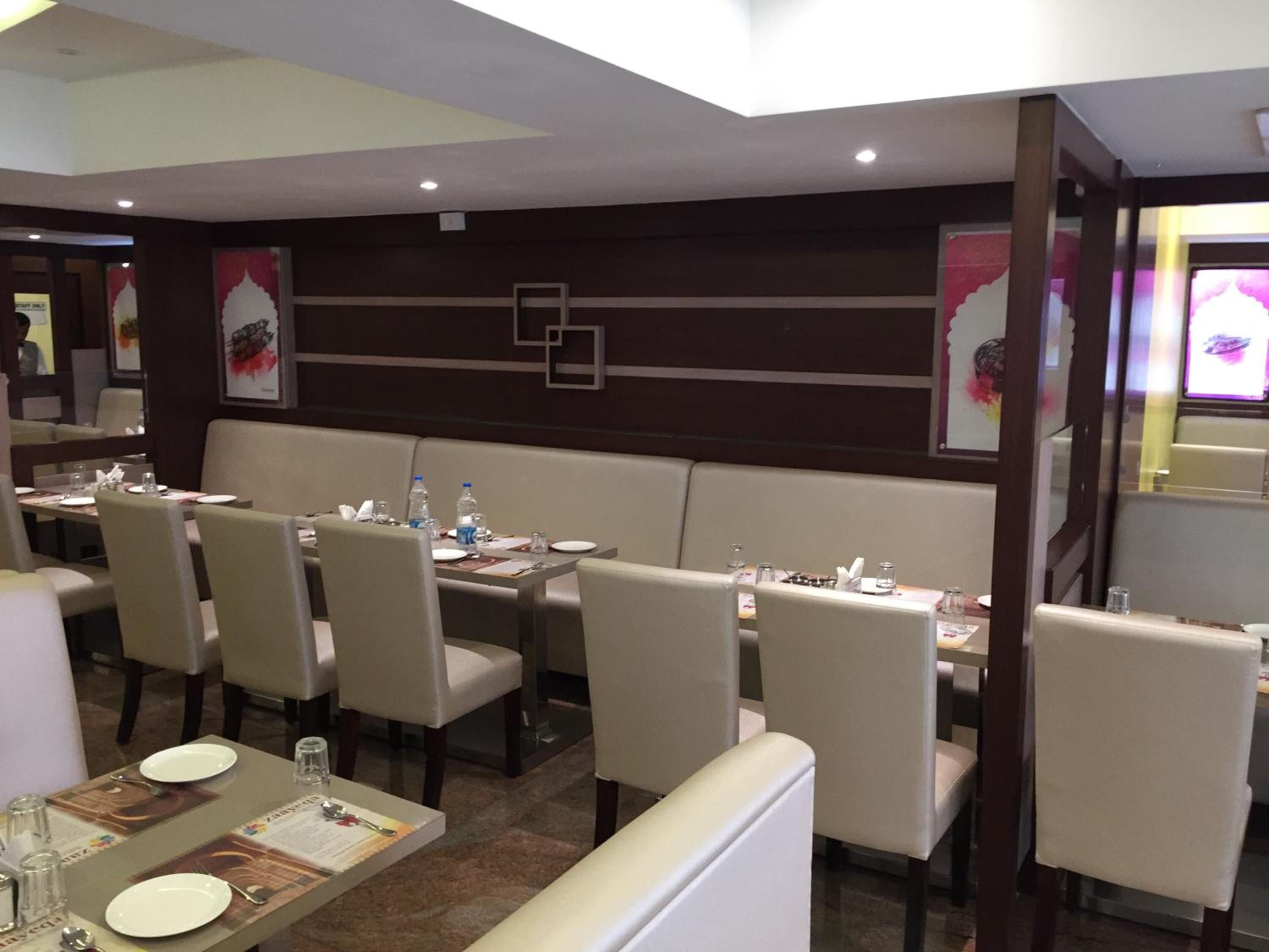A restaurant with booths and tables, some with water bottles and menus.