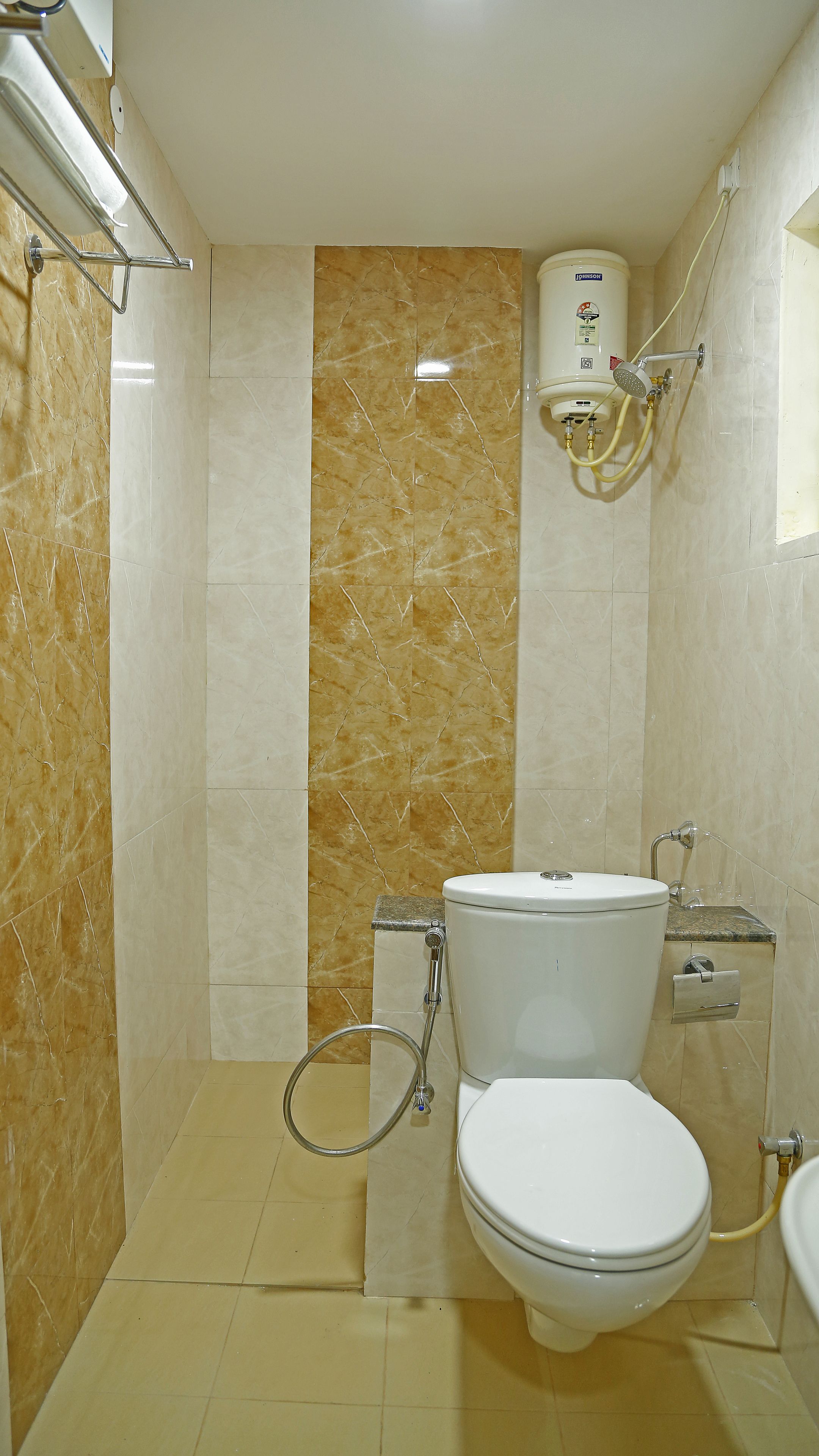 A bathroom with a toilet, a shower, and a hand dryer.