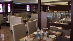 Un ristorante con banconi e tavoli, alcuni con bottiglie d'acqua e menu.