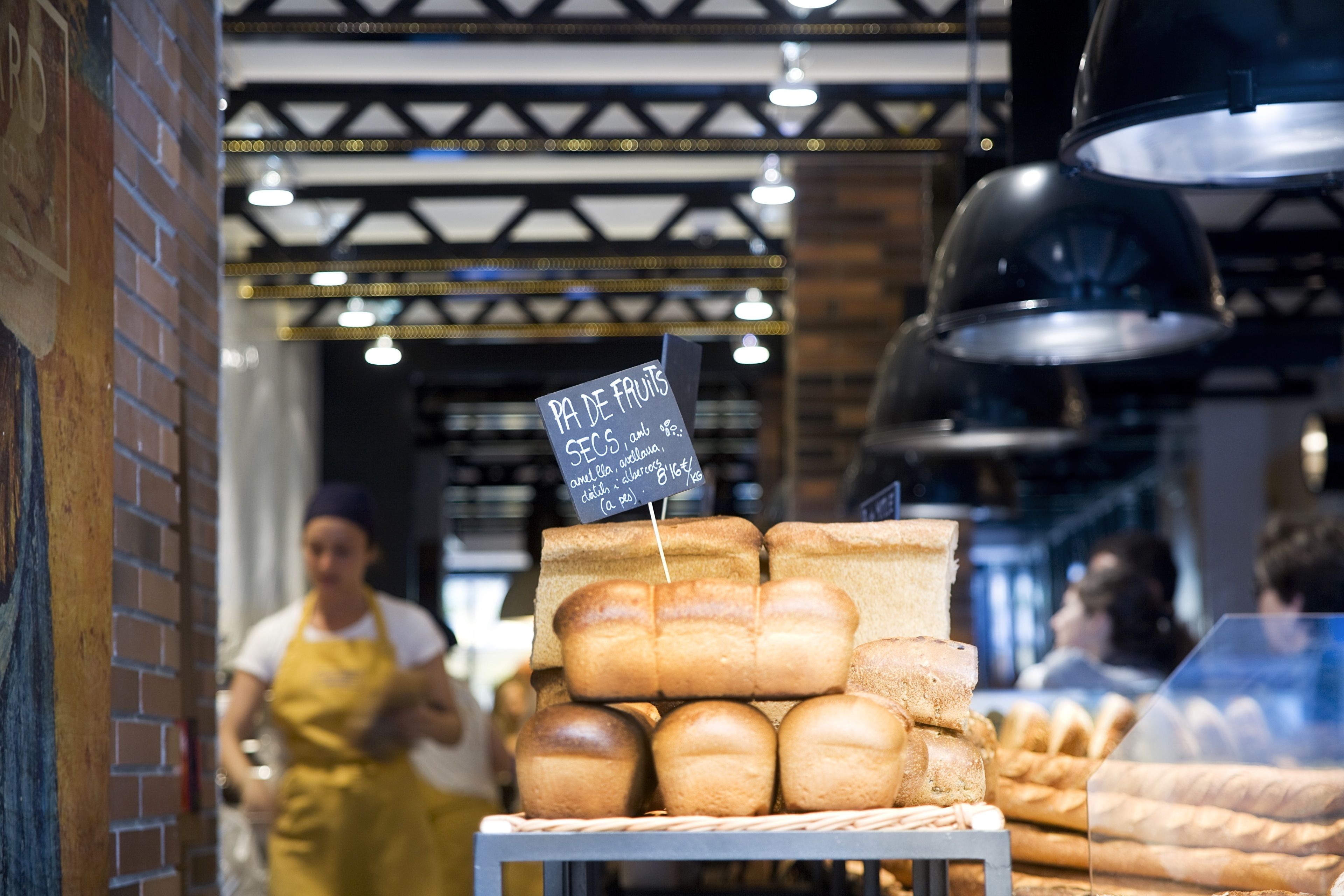 A bakery display with various breads and a sign indicating the price.