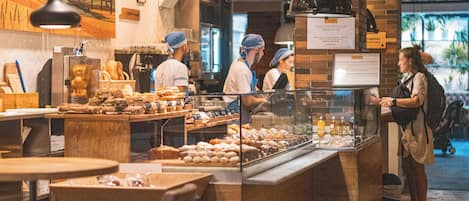 A bakery counter with pastries, a coffee machine, and a menu sign.