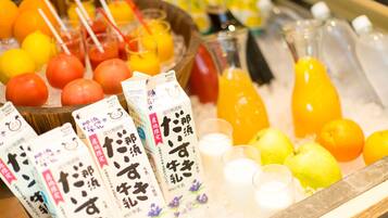 A display of beverages and fruits, including juice cartons and bottles, on a tray.