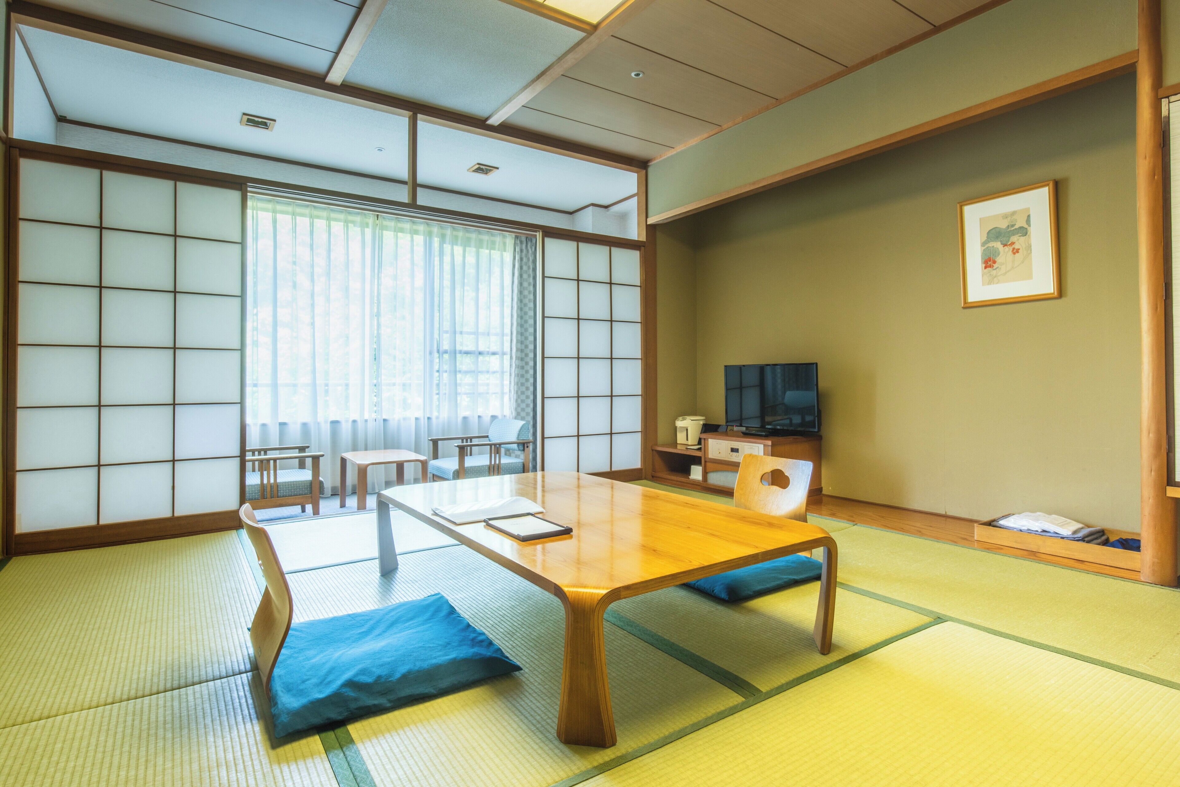 Una habitación japonesa tradicional con suelo de tatami, una mesa baja y paneles shoji.
