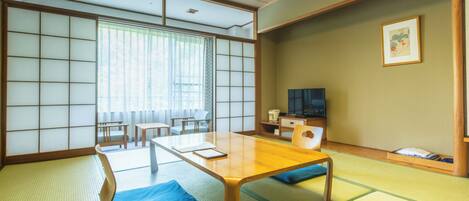 A traditional Japanese room with tatami flooring, a low table, and shoji screens.