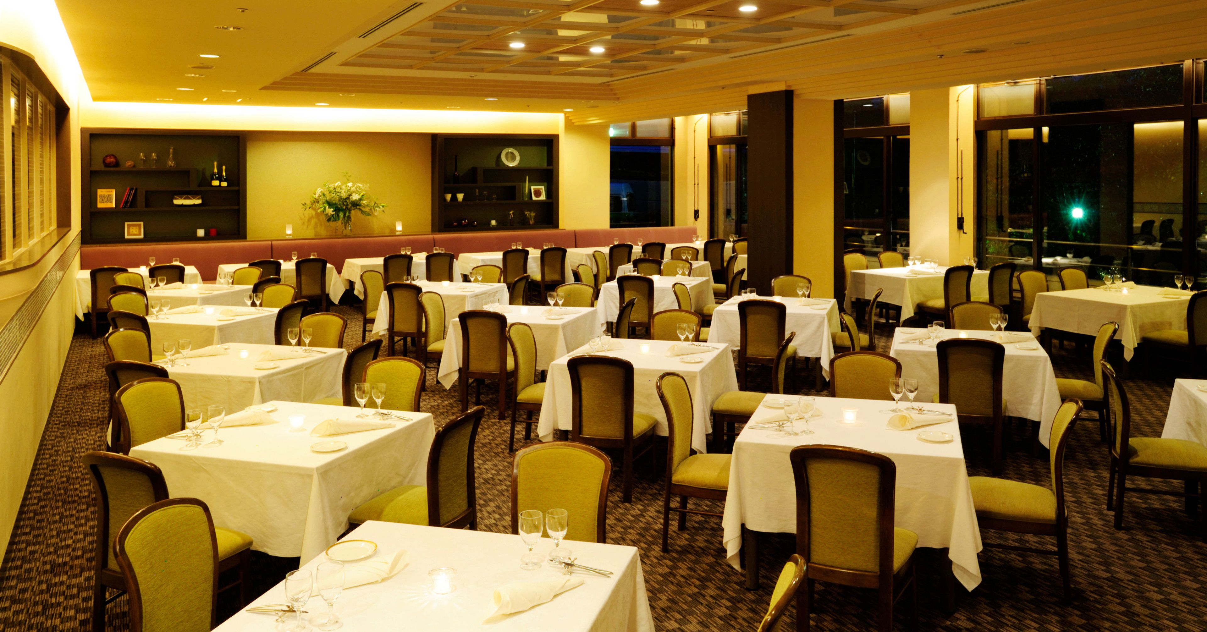 A restaurant with multiple tables and chairs, arranged in a spacious layout.