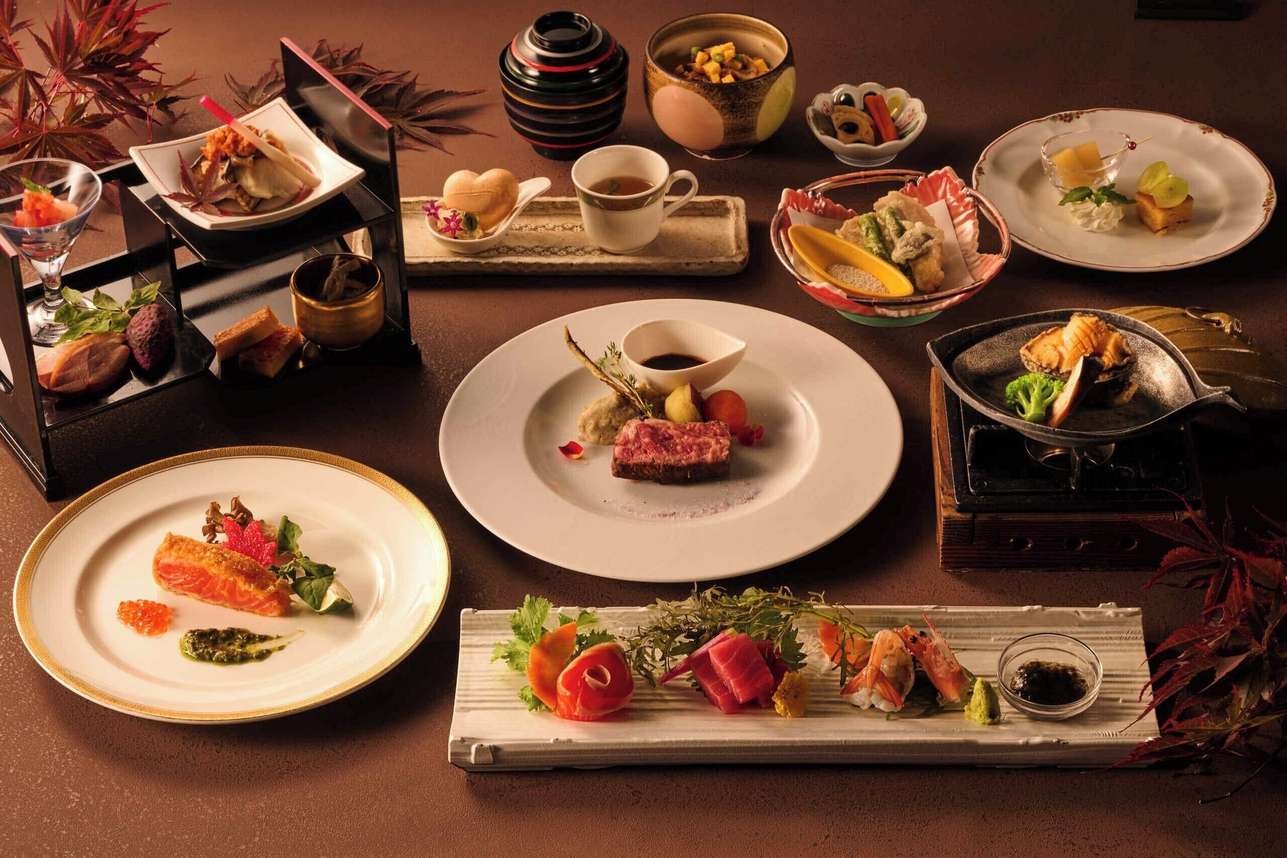 Une variété de plats disposés sur une table, notamment des sushis, des sashimis et d’autres amuse-gueules.