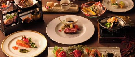 Une variété de plats disposés sur une table, notamment des sushis, des sashimis et d’autres amuse-gueules.