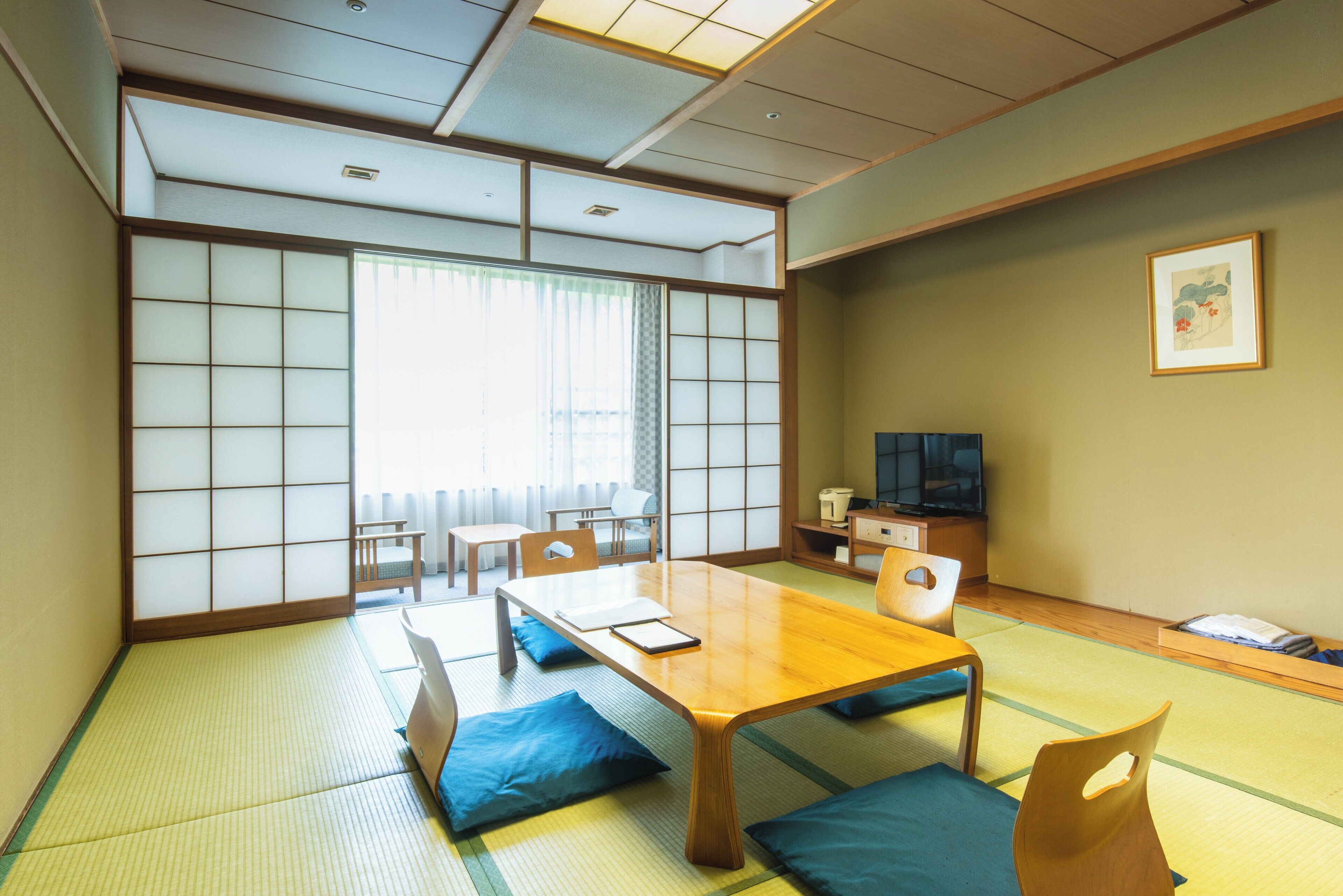 A traditional Japanese-style room with tatami flooring, a low table, and shoji screens.