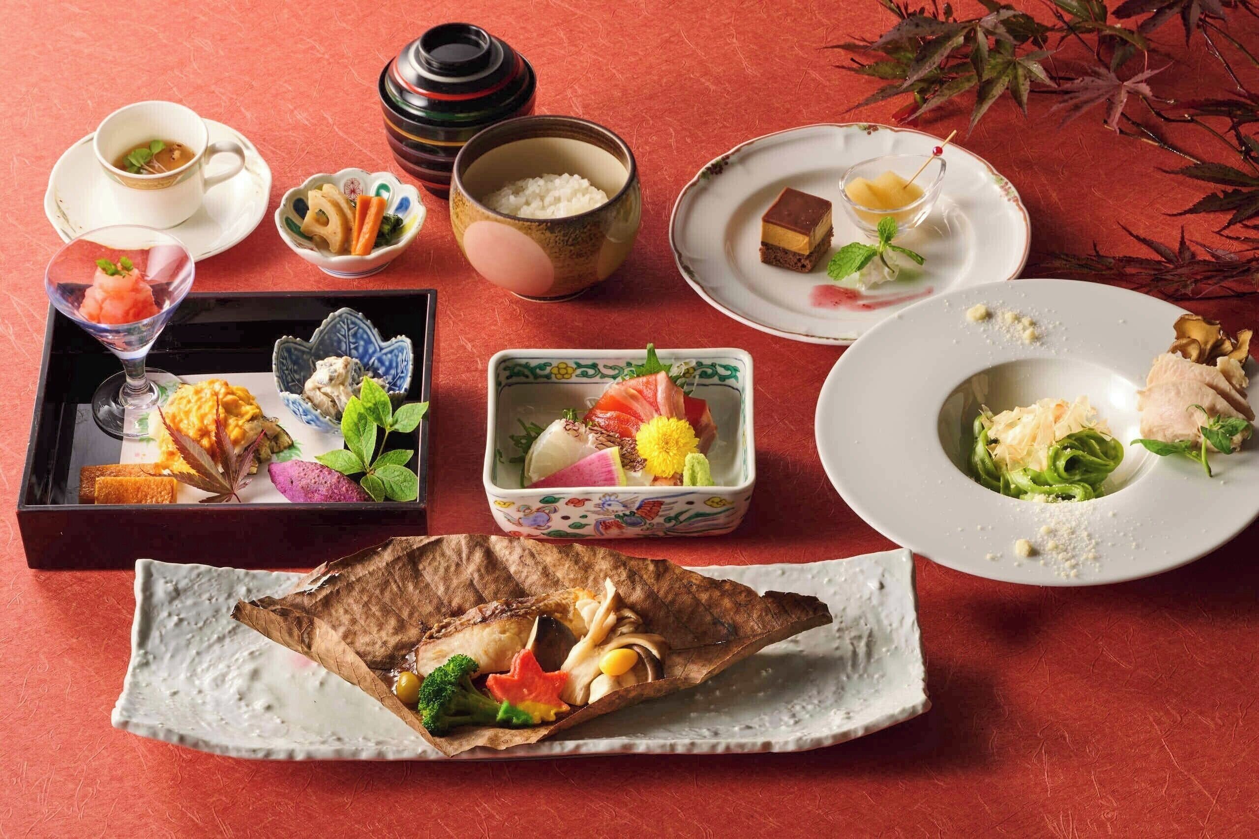 A variety of Japanese dishes arranged on a table, including sushi, sashimi, and a bowl of rice.