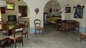 Un coin repas avec une table ronde et des chaises, une chaise séparée et une table à manger en arrière-plan.