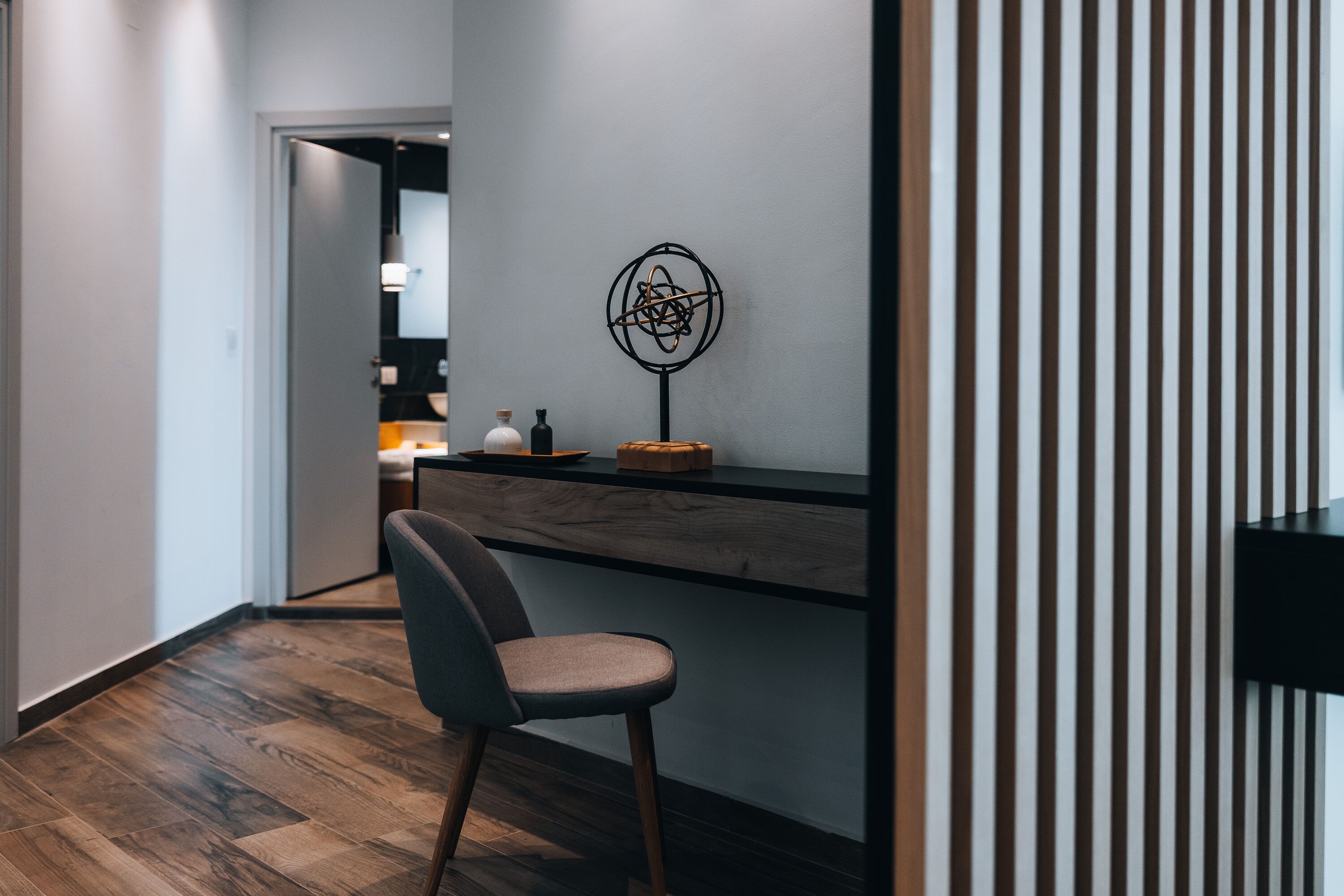 Een moderne keuken met een houten aanrecht, een stoel en een decoratief wandobject.