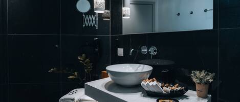 Une salle de bain moderne avec un grand lavabo blanc, un miroir et un porte-serviettes.