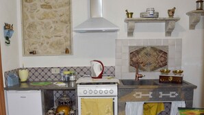 Una cocina compacta con estufa, refrigerador y un salpicadero decorativo.