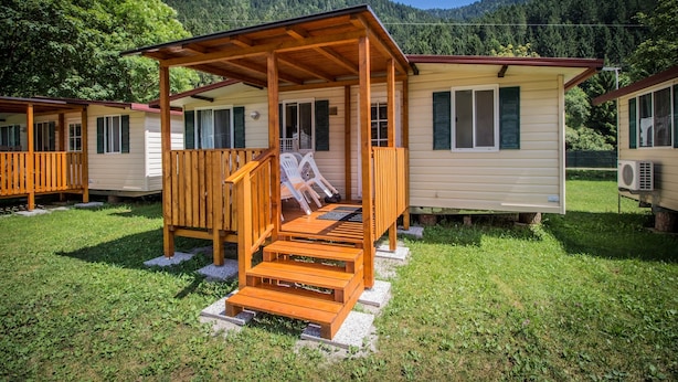 Eine Reihe von Holzhütten mit einer überdachten Veranda und Treppen zum Eingang.