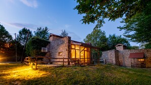 A rustic stone building with a wooden fence, a small porch, and a well-lit interior. - Hindiba Doga Evi (Mengen)