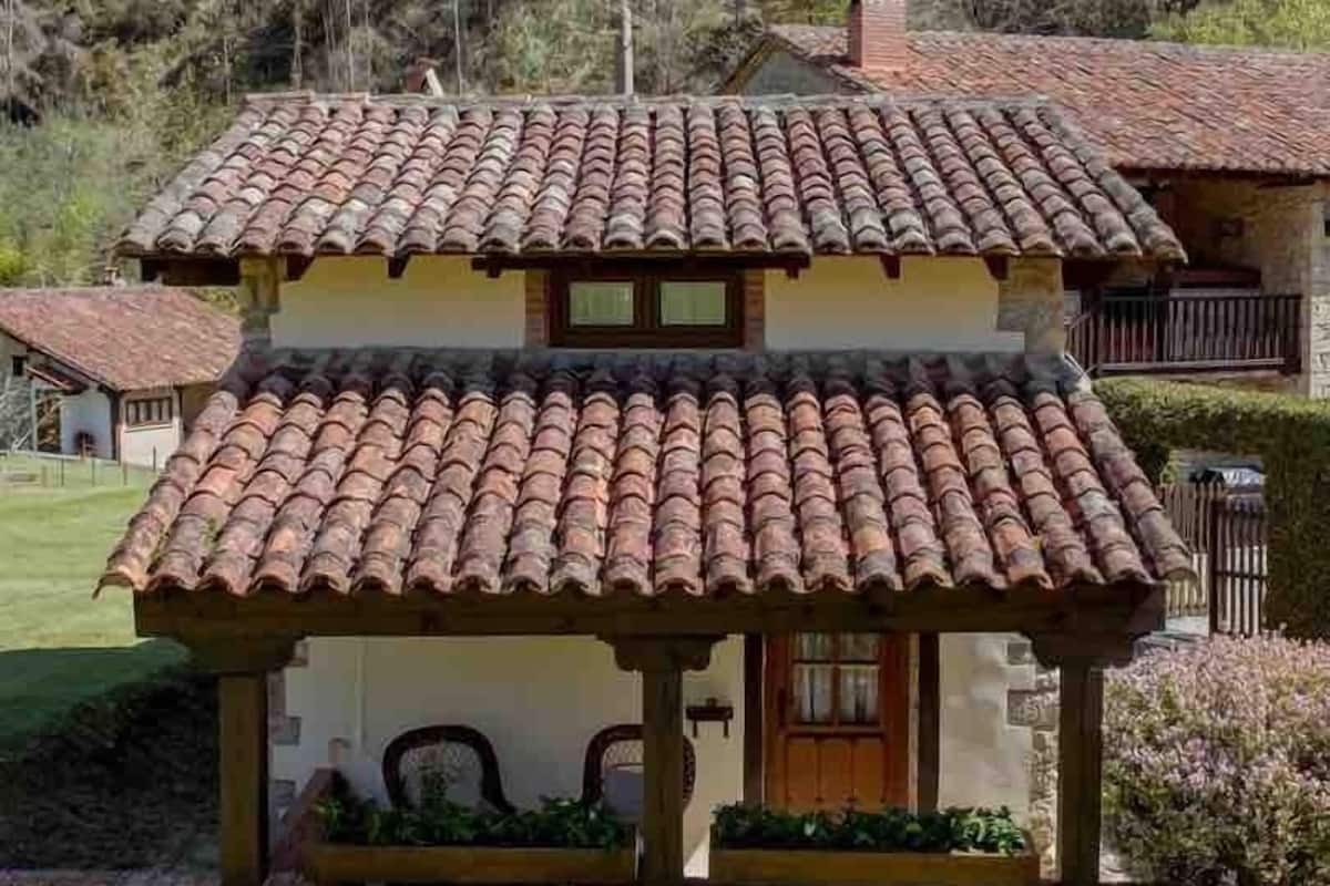 A two-story house with a tiled roof and a covered porch.