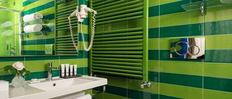 A bathroom with green tiled walls, a white sink, and a towel rack.