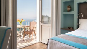 Een hotelkamer met balkon, een bed, een stoel en een tafel met bloemen.
