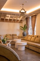 Una sala de estar moderna con un sofá modular, una mesa de centro redonda y una planta en maceta.