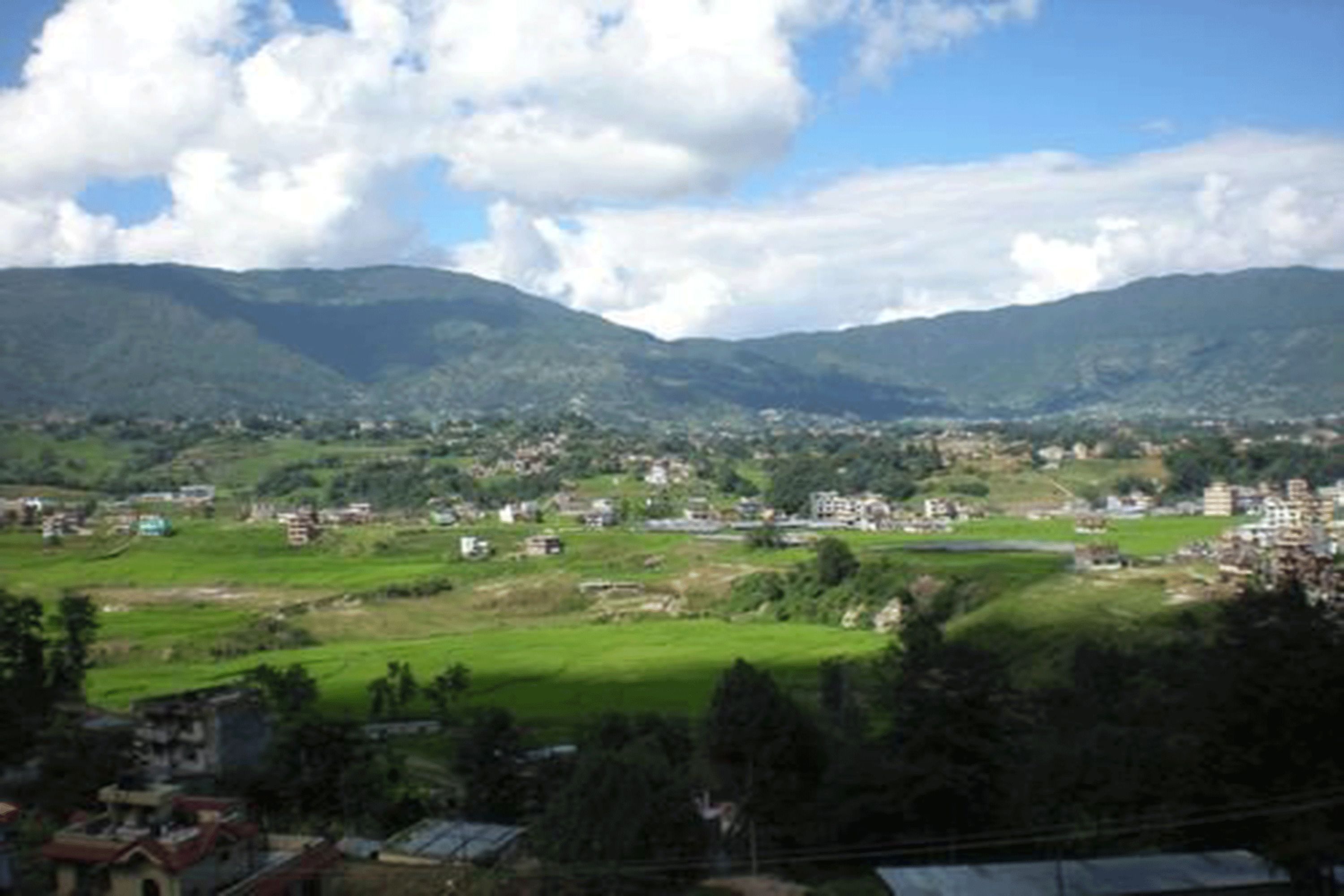 A mountainous landscape with a village in the valley.