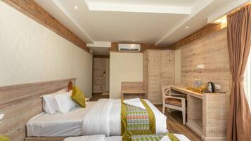 A hotel room with two beds, a desk, and a wardrobe.