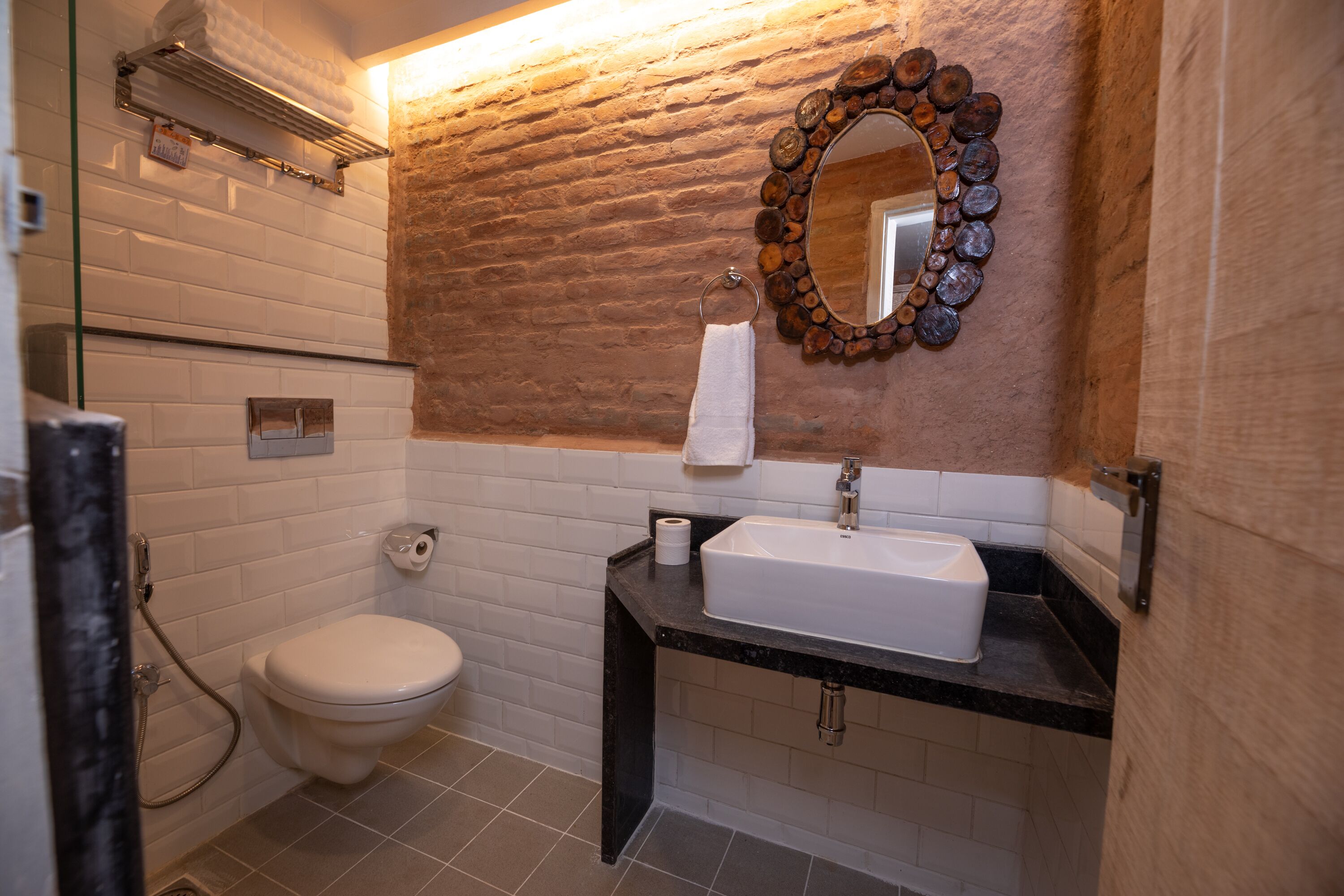A bathroom with a white toilet, a sink with a mirror above it, and a towel rack.