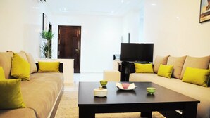 Una sala de estar moderna con dos sofás, una mesa de centro y una televisión.