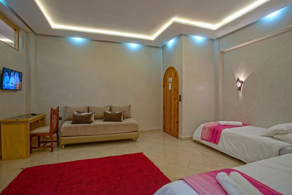 Una habitación de hotel con sofá, cama, escritorio y televisor.