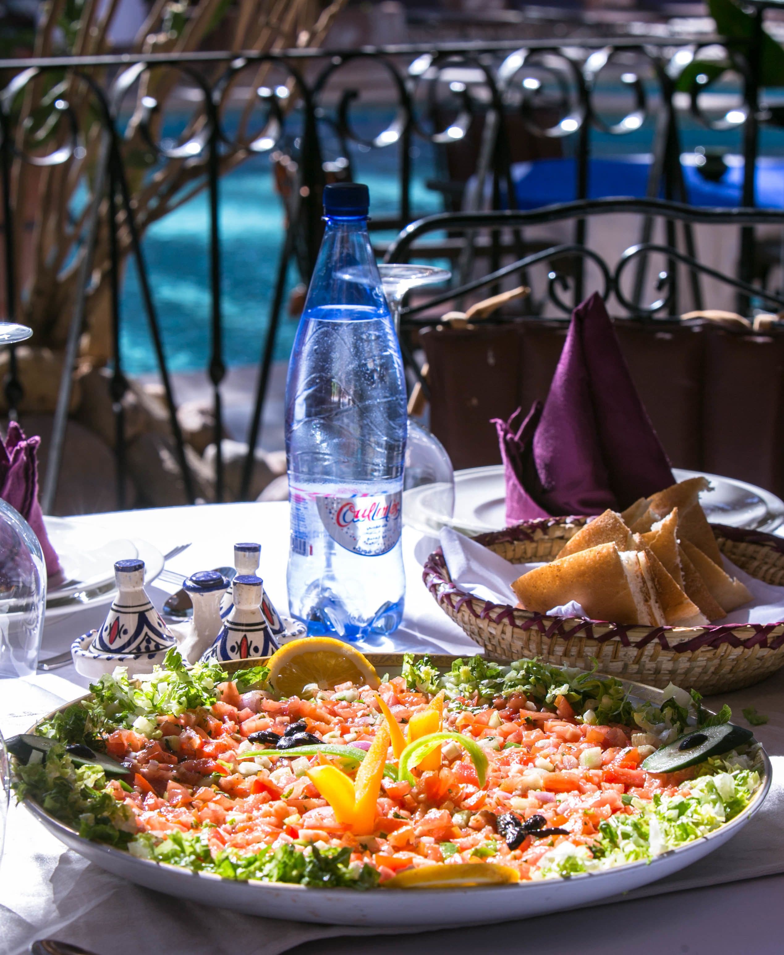 Ein Tisch mit Salat, Brot und einer Wasserflasche.