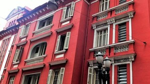 Un edificio rojo con múltiples ventanas y balcones.
