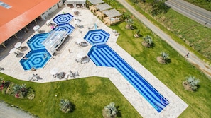 A large outdoor swimming pool area with multiple pools, sun loungers, and a covered seating area. - Hotel Fazenda Dona Francisca (Joinville)