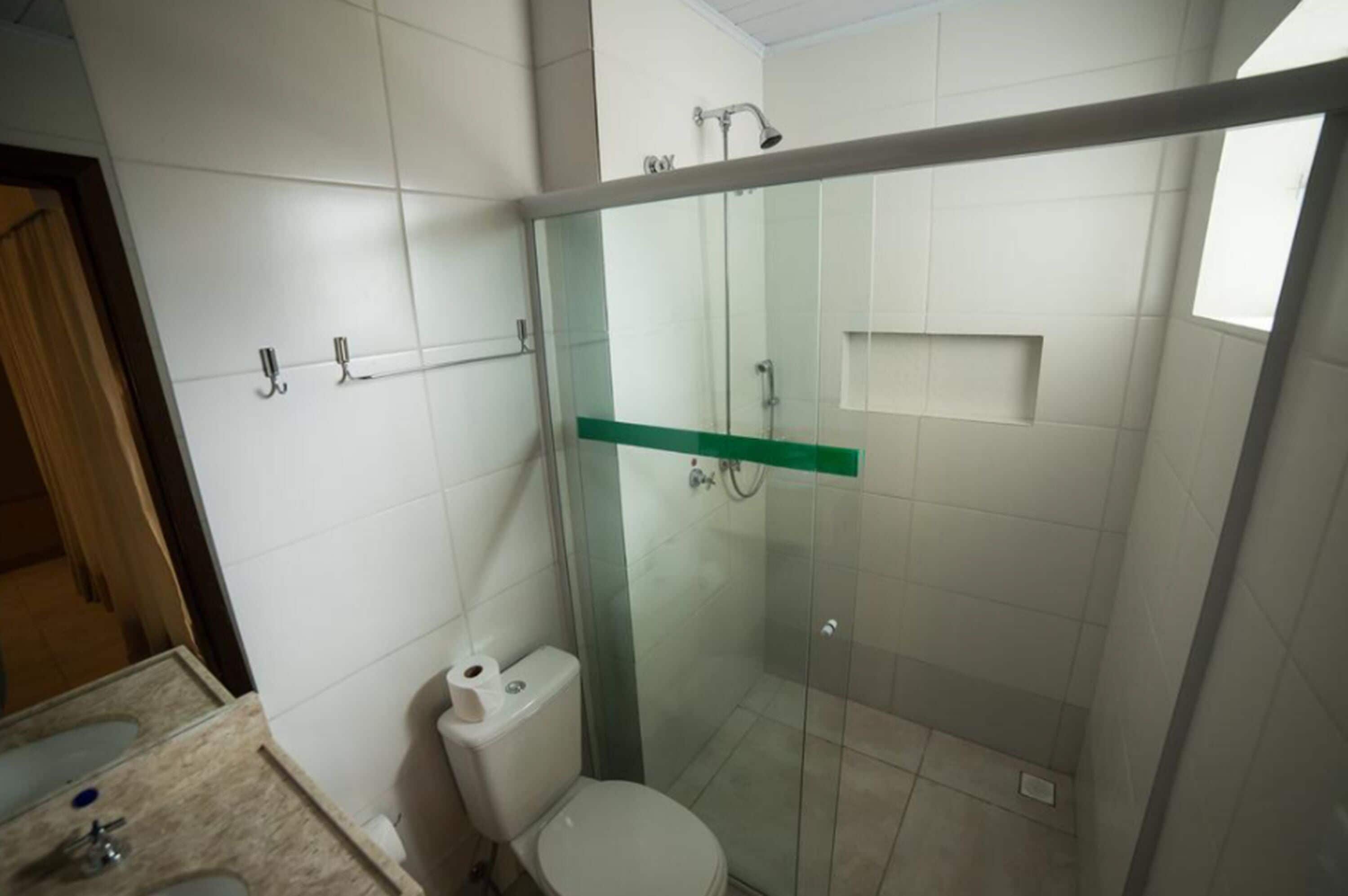 A modern bathroom with a glass-enclosed shower, a toilet, and a sink.