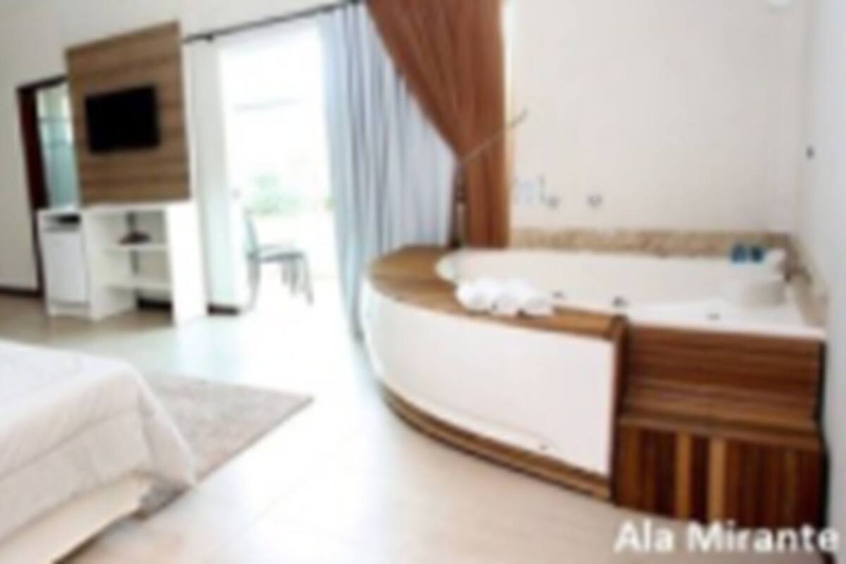 Una habitación de hotel moderna con cama, escritorio, tocador con espejo y bañera.