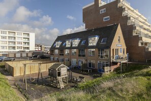A multi-story building with a flat roof, large windows, and a balcony. - Beach House Egmond aan Zee (Egmond aan Zee)