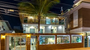 A residential building with a well-lit entrance, a visible balcony, and a sign indicating the name and address. - Pousada Tissiano (Florianópolis)