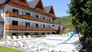 Ein Hotel mit Poolbereich, mehreren Balkonen und einer Skilift.