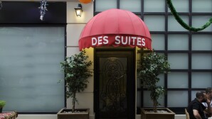 The entrance to a hotel named 'DES SUITES' with a red awning, a decorative door, and potted plants on either side. - Bakırköy DES Suit Otel (Istanbul)