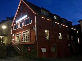 A red building with the sign "STEAKHAUS" indicating a restaurant. There are multiple windows and a staircase leading to the entrance.