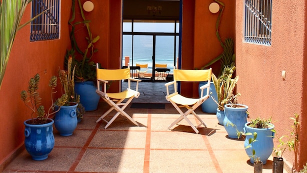 An outdoor seating area with two yellow chairs and potted plants. - Daribis (Sidi Ouassay)