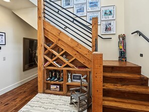 Una escalera de madera con una estantería empotrada y una pequeña mesa.