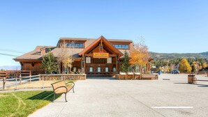 A lodge with a sign for lift tickets and season passes, a covered outdoor seating area, and a view of the surrounding mountains. - Downtown Location - Steps to Gondola, Hot Tub, DOG FRIENDLY SCC3 (Breckenridge)