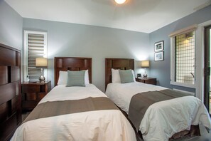 A hotel room with two beds, wooden headboards, bedside tables with lamps, a window with blinds, and a picture on the wall. - Wailea Ekolu #105 Scenic Ocean View, Great Location, Near Beaches, Full AC (Wailea)