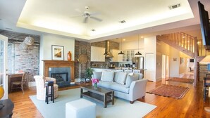A spacious living area with a fireplace, a dining area, and a kitchen.