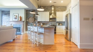 A modern kitchen with a central island, white cabinets, and stainless steel appliances.