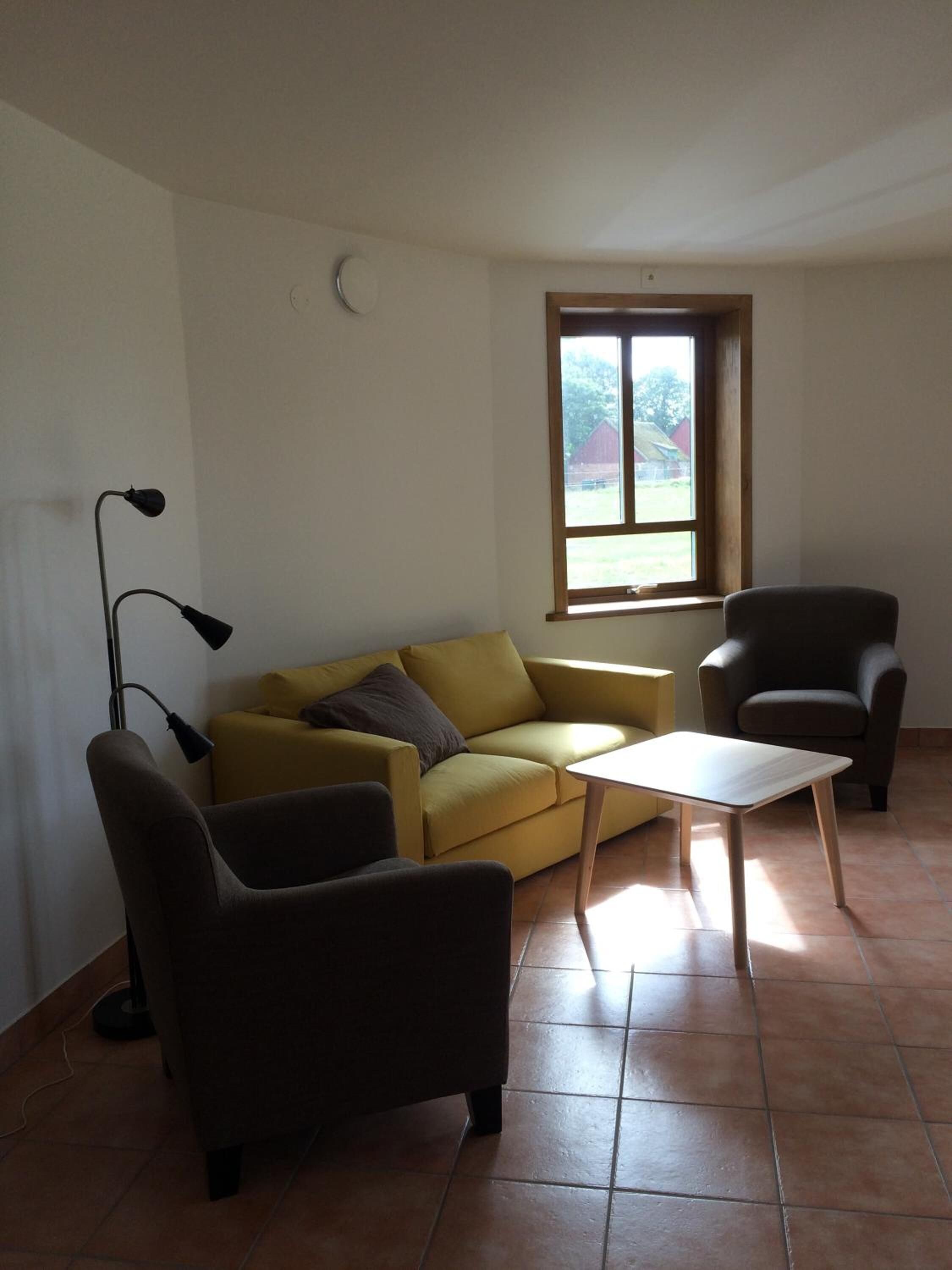 Una sala de estar con un sofá, un sillón y una mesa.