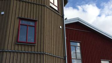 Un edificio de varios pisos con fachada de madera y ventanas de marco rojo.